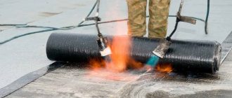 Мастер укладывает рулонную кровлю