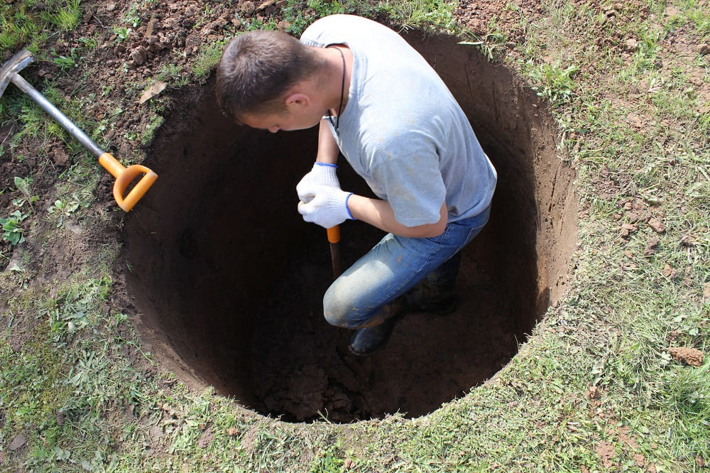 Мужчина копает яму